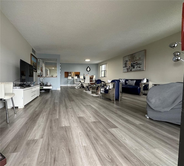 living room featuring light hardwood / wood-style flooring and a textured ceiling