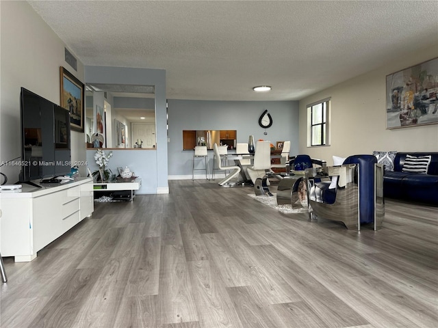 living room featuring a textured ceiling and light hardwood / wood-style floors