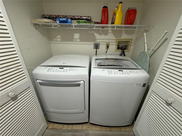 washroom with light wood-type flooring and washer and clothes dryer