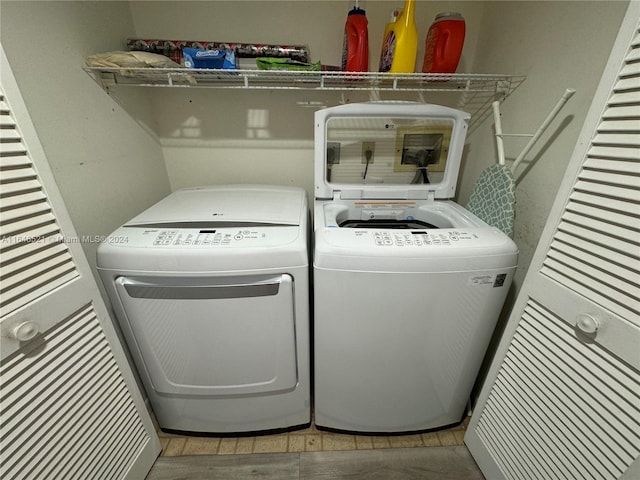 clothes washing area with light hardwood / wood-style floors and independent washer and dryer