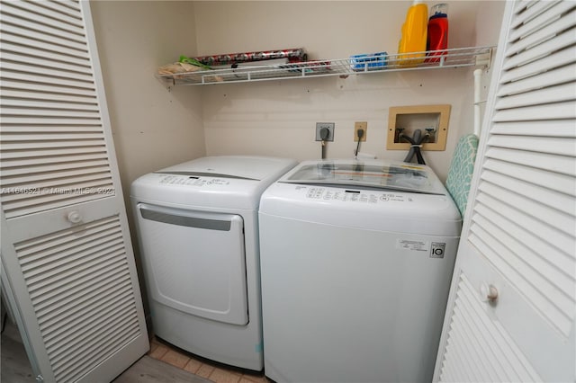 clothes washing area with separate washer and dryer and light hardwood / wood-style flooring