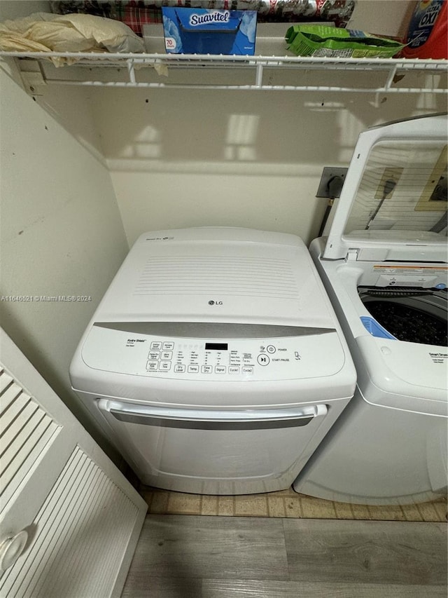 laundry area with hardwood / wood-style flooring and washing machine and dryer