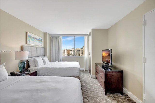 bedroom featuring dark carpet and baseboards