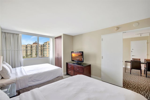 bedroom featuring light carpet and baseboards