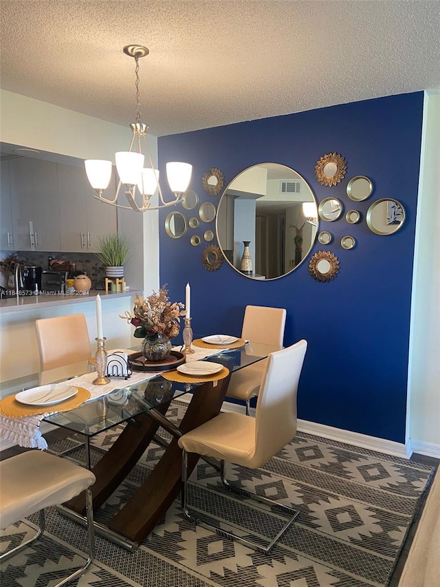 dining space with a notable chandelier and a textured ceiling