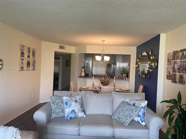 living room featuring a chandelier, a textured ceiling, and hardwood / wood-style flooring