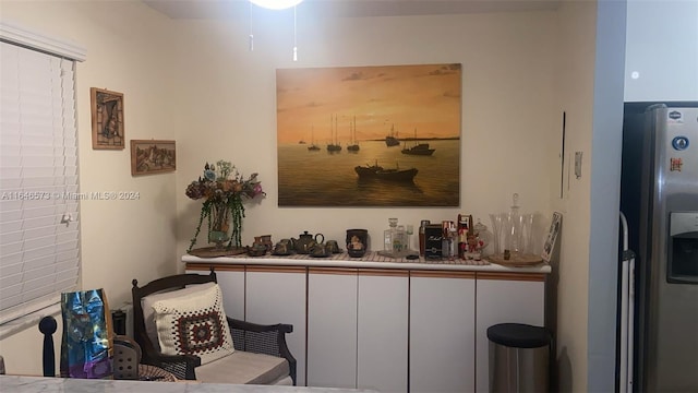 interior space with stainless steel fridge with ice dispenser and white cabinets