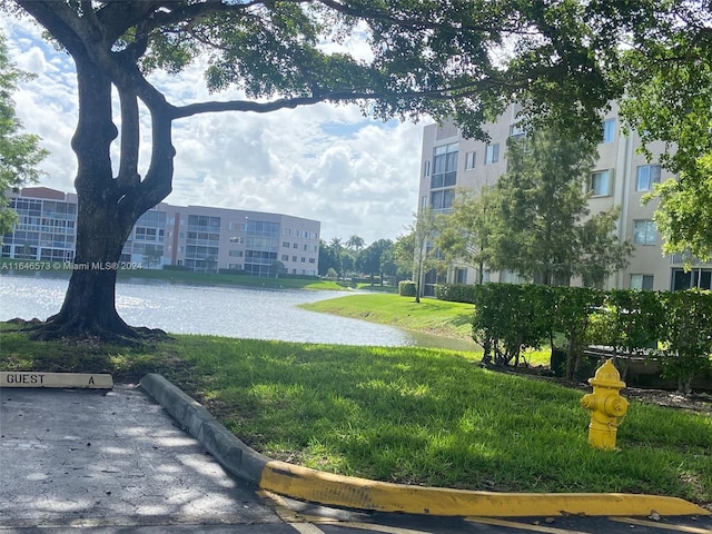 view of property's community with a lawn and a water view