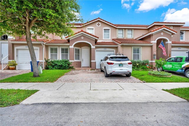 view of front of house featuring stucco siding, a tile roof, and decorative driveway