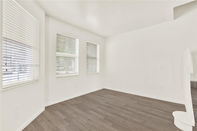 unfurnished room featuring wood finished floors and baseboards