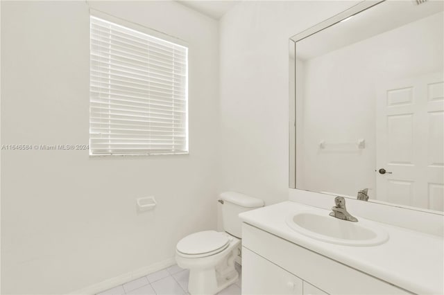 bathroom featuring vanity, tile patterned floors, toilet, and baseboards