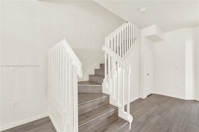 stairway with baseboards and wood finished floors