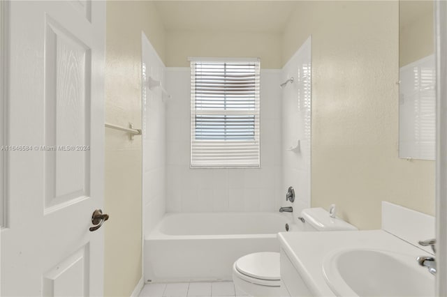 bathroom with tile patterned flooring, toilet, washtub / shower combination, and a sink