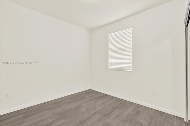 unfurnished room with wood finished floors and baseboards