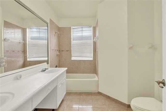 bathroom with toilet, a sink,  shower combination, tile patterned flooring, and baseboards