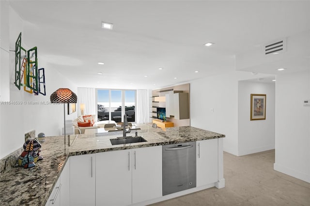 kitchen featuring sink, dishwasher, kitchen peninsula, white cabinetry, and dark stone counters