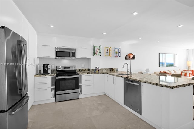 kitchen featuring appliances with stainless steel finishes, kitchen peninsula, and white cabinets