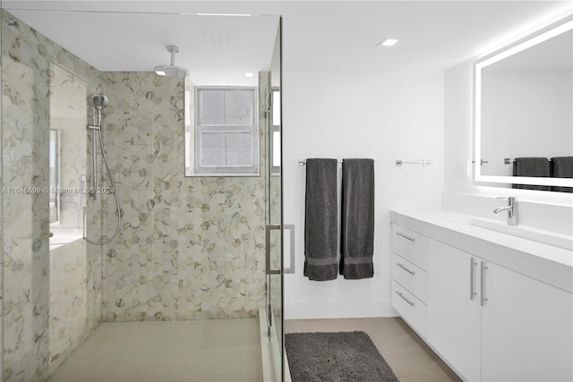 bathroom featuring a shower with door, vanity, and tile patterned floors