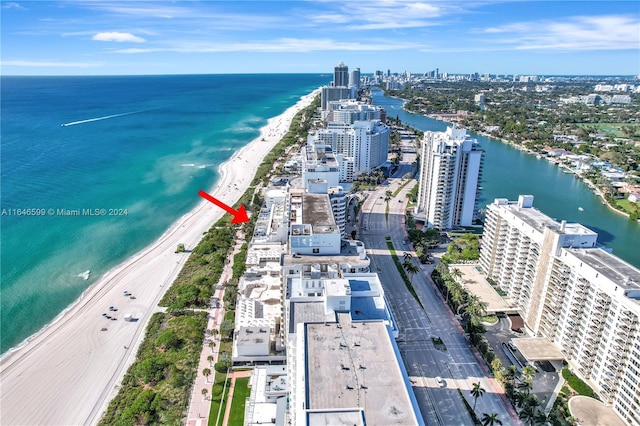 birds eye view of property with a water view and a beach view