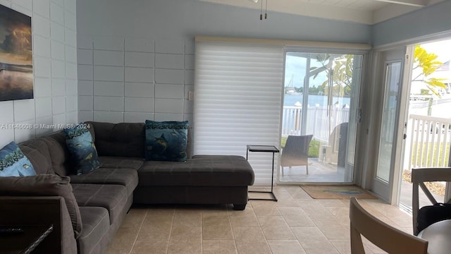 living room featuring light tile patterned floors, a healthy amount of sunlight, and tile walls