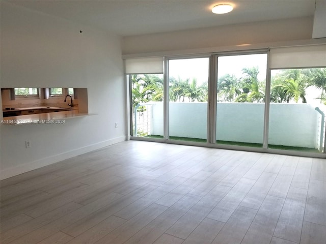 unfurnished living room featuring light hardwood / wood-style floors and sink