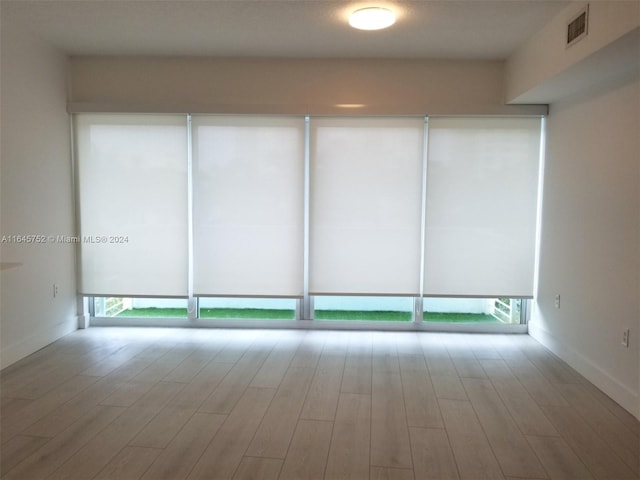 unfurnished room featuring hardwood / wood-style flooring and a healthy amount of sunlight