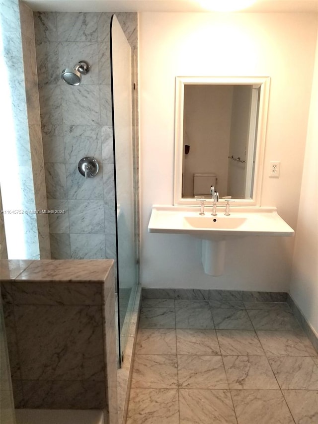 bathroom with tiled shower and tile patterned floors