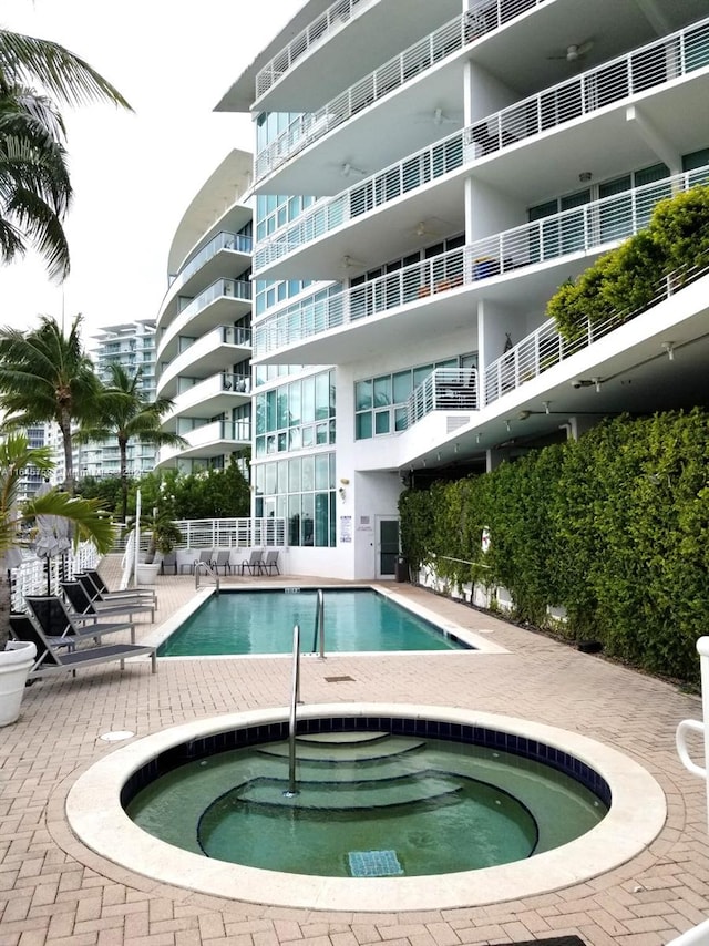 view of pool with a hot tub