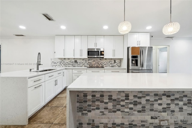 kitchen with appliances with stainless steel finishes, white cabinetry, sink, light tile patterned flooring, and hanging light fixtures