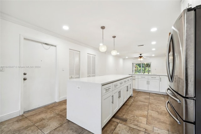 kitchen with ceiling fan, a kitchen island, white cabinets, light tile patterned floors, and stainless steel fridge