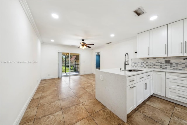 kitchen with ceiling fan, backsplash, white cabinetry, light tile patterned floors, and sink