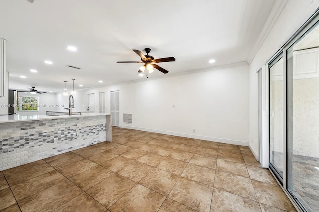 unfurnished living room with ceiling fan, ornamental molding, and light tile patterned floors