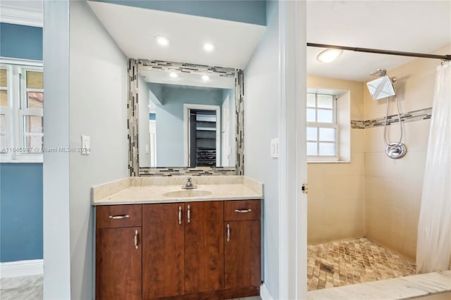 bathroom with tile patterned flooring, a shower with curtain, tasteful backsplash, and vanity