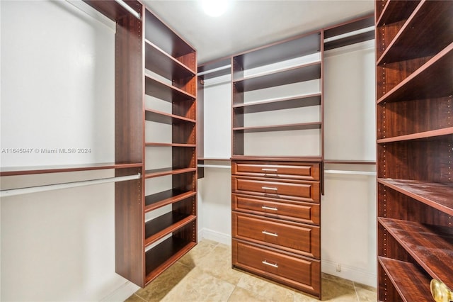 walk in closet with light tile patterned floors