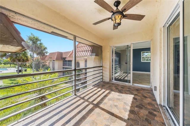 unfurnished sunroom with ceiling fan