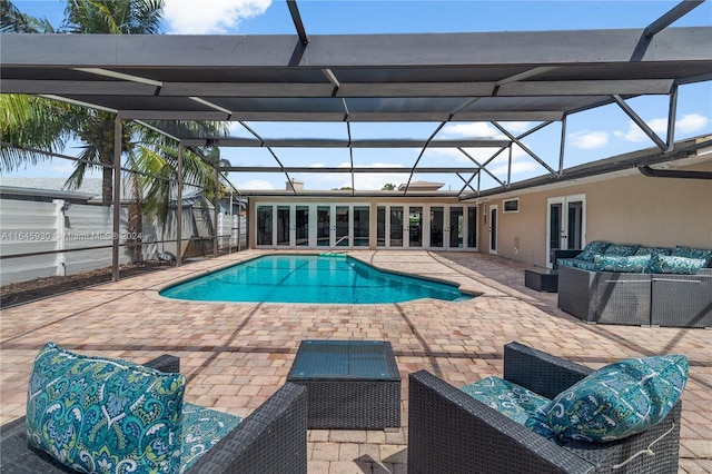 view of swimming pool with french doors, an outdoor living space, a patio area, and a lanai