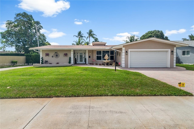 ranch-style house featuring a garage and a front lawn