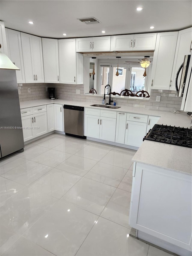 kitchen featuring decorative backsplash, white cabinetry, sink, and stainless steel appliances