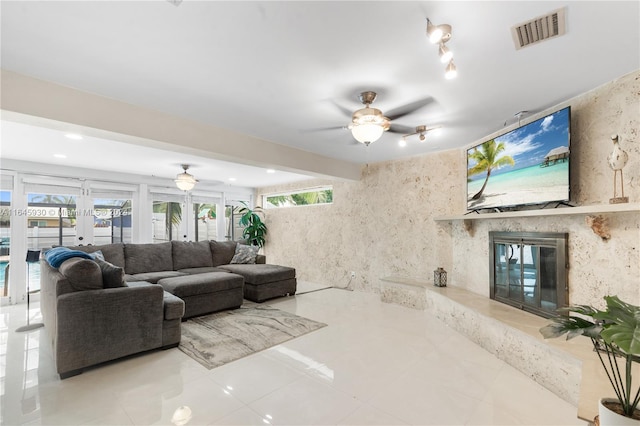 living room with a wealth of natural light, french doors, ceiling fan, and light tile patterned floors