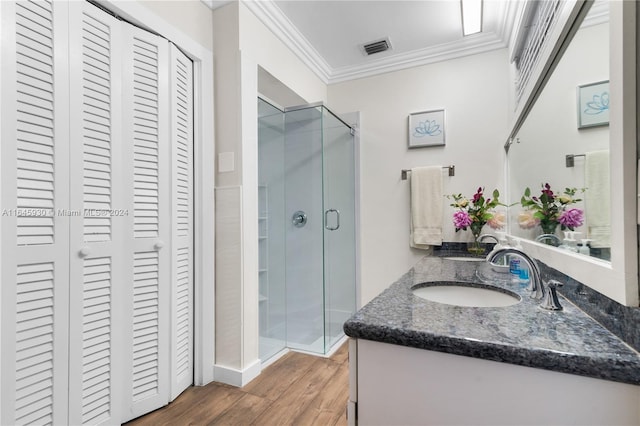 bathroom with hardwood / wood-style floors, vanity, an enclosed shower, and crown molding