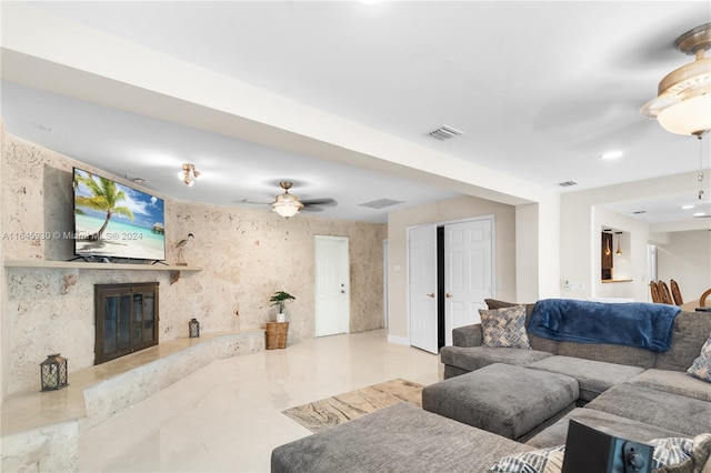 living room with ceiling fan and a high end fireplace