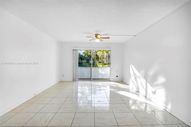 tiled empty room featuring a textured ceiling and ceiling fan