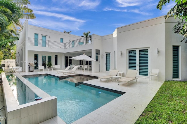 rear view of house with a patio and a balcony