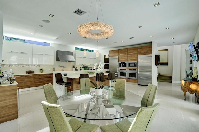 tiled dining room with an inviting chandelier