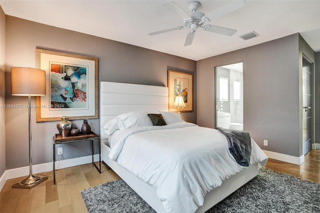 bedroom featuring hardwood / wood-style floors, ensuite bathroom, and ceiling fan