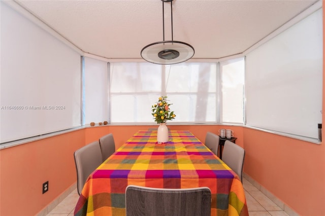 dining space with a textured ceiling and light tile patterned floors