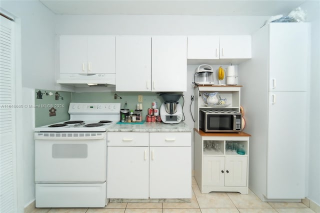 kitchen with electric stove, tasteful backsplash, light tile patterned floors, and white cabinetry