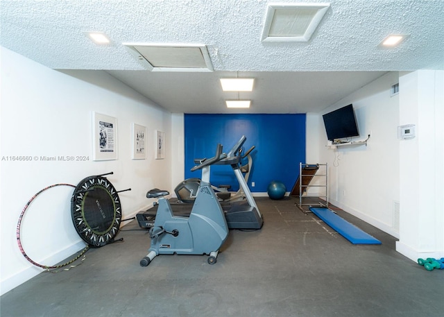 exercise room featuring a textured ceiling