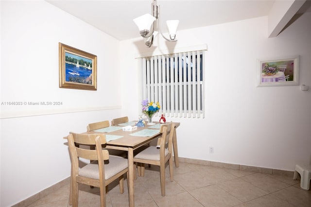 tiled dining space featuring a notable chandelier