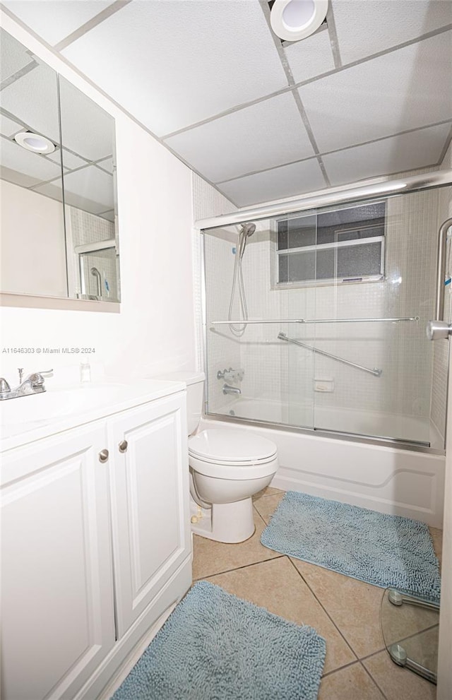 full bathroom with vanity, toilet, a paneled ceiling, and bath / shower combo with glass door